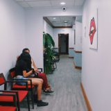 A woman sitting on the ground in a waiting room.