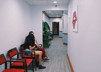 A woman sitting on the ground in a waiting room.