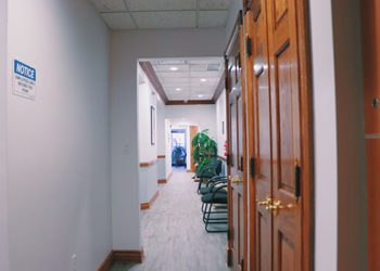 A hallway with chairs and a wall in the background.