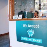 A woman sitting at the front desk of a business.