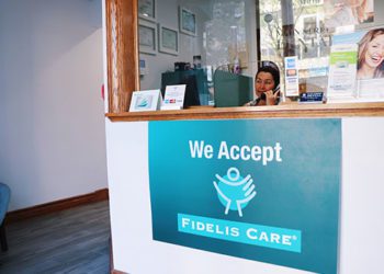 A woman sitting at the front desk of a business.