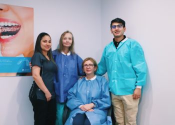 A group of people standing in front of a wall.